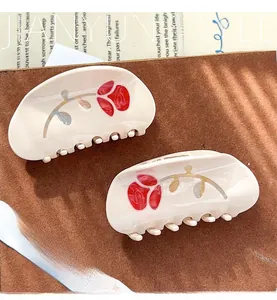 Detail of cream shark hair clips with red rose pattern and high-quality finish