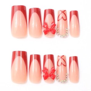 Détails de faux ongles French rouges avec nœuds 3D, cœurs et strass étincelants