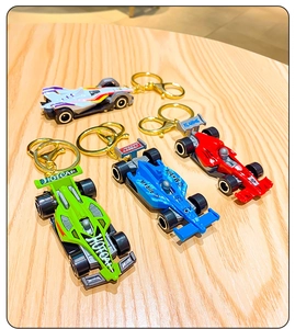 Detailed view of colorful F1 racing car keychains on a wooden surface with metal rings