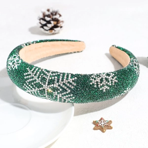 Detail of green sponge headband with sparkling rhinestone snowflake patterns and pine cone