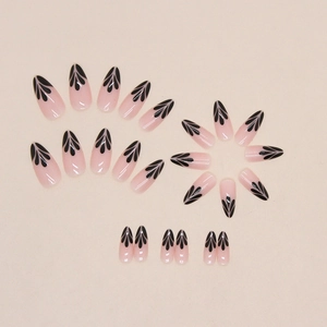Almond-shaped press-on nails with nude base and black petal floral art design