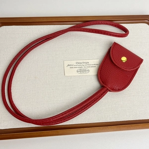 Détail du support de lunettes en cuir litchi rouge avec un bouton-pression doré chic