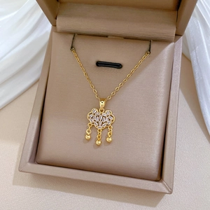 Macro view of gold Ruyi lock pendant with sparkling crystals in a premium gift box