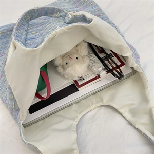 Macro view of tweed tote bag interior showing spacious storage for laptop and daily items