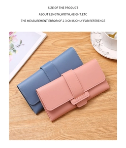 Lifestyle shot of pink and blue pebble leather wallets on a wooden surface with decor