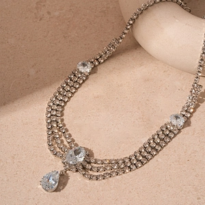 Détail macro du collier argenté à trois couches avec pendentifs en zircone poire