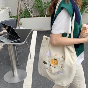 Détail du sac cabas en velours côtelé avec broderie cartoon et fermoir magnétique bronze