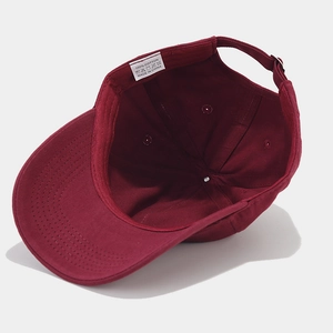 Deep red cotton baseball cap interior view showing adjustable strap and stitching