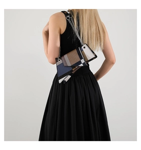 Model back view showing contrast geometric crossbody bag with silver chain and plaid pattern