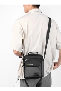 Vertical black nylon men's crossbody bag with adjustable strap and multiple compartments