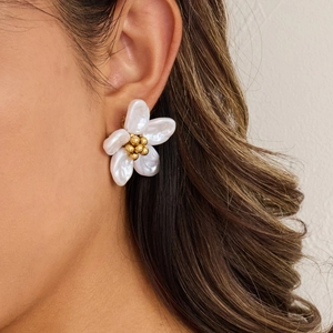 Close-up of 18K gold stainless steel flower earring with white opal petals on model