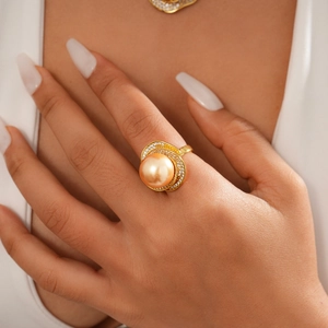 Close-up of luxury gold ring with a large champagne pearl and micro-inlaid diamonds