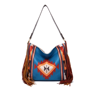 Close-up of bohemian woven tote bag featuring tribal patterns and long brown side tassels
