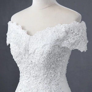 Nahaufnahme eines schulterfreien weißen Hochzeitskleides mit Pailletten und Blumendetails