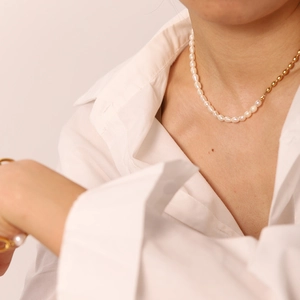 Détail macro du collier en perles d'eau douce et perles plaquées or 18K sur modèle