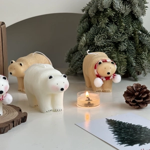 Polar bear shaped candles in white and brown with mini Christmas trees and pine cones