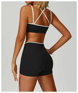 Close-up of contrast color sports bra with cross-back straps and matching shorts