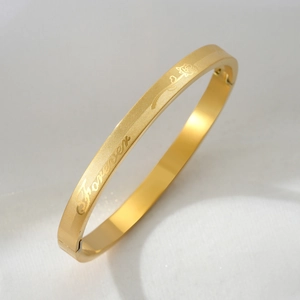 Titanium steel gold bangle with engraved flowers and forever love text on white background