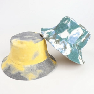 Close-up of reversible tie-dye bucket hats in yellow-grey and blue-white canvas fabric