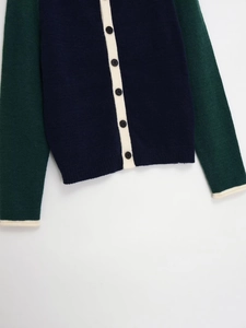 Detailed view of tricolor patchwork knit cardigan with classic buttons and fine texture