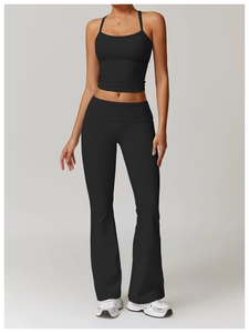 Full view of black halter yoga tank top and high-waisted flared pants on model