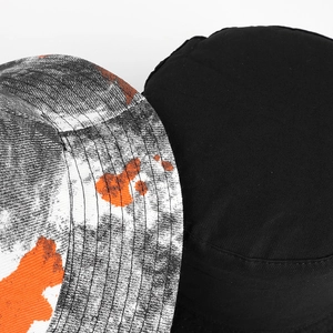 Tie-dye and black reversible bucket hat featuring vibrant orange ink splatter patterns