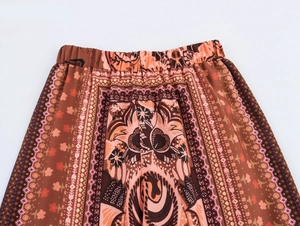 Detail of bohemian wide-leg trousers with elastic waistband and ethnic geometric patterns