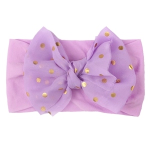 Detail of soft purple nylon baby headband featuring a large tulle bow with golden polka dots