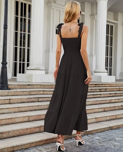 Detail of black backless maxi dress showing strappy tiered design and ruffled back details