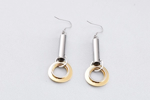 Détail de boucles d'oreilles géométriques avec cercles dorés mats et argentés polis