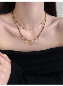 Detail of layered sun and star beaded necklace with tiger eye stones on model