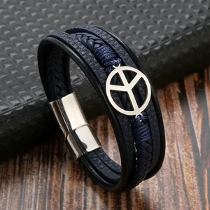 Detail of dark blue multilayer braided leather bracelet with metal peace sign and magnetic clasp