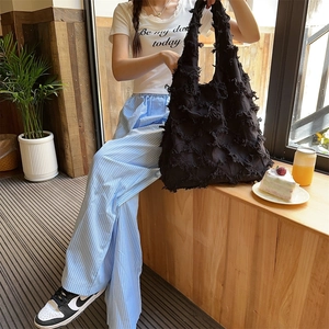 Detail view of large black canvas tote bag featuring unique layered tassel fringe texture