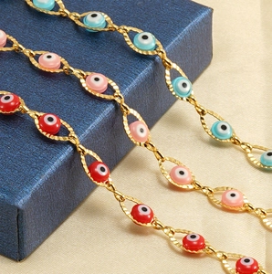 Vue détaillée de trois bracelets œil maléfique en rouge, rose et bleu sur chaîne dorée