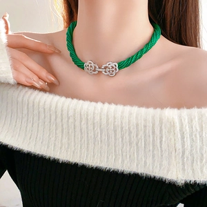 Detail of emerald multi-strand beaded necklace with sparkling silver camellia flower clasps