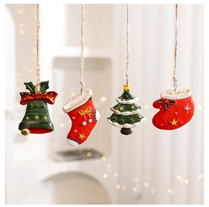 Detailed view of mini resin Christmas ornaments with bells, stockings and rustic twine
