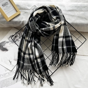 Classic black and white checkered scarf with soft fringes displayed on a metal grid