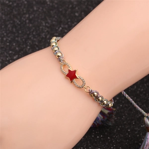 Detail of red star infinity bracelet with colorful beads and bohemian tassels on wrist