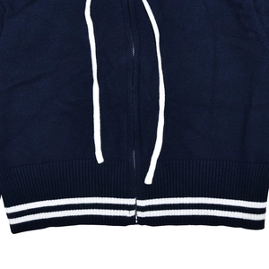Detail of navy knit jacket hem with white stripes, functional zipper and drawstrings