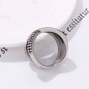 Detail of silver dual-layer woven ring featuring granular texture and polished steel finish