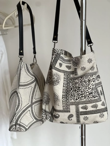 Detail of canvas tote bags with geometric and paisley prints and black leather straps