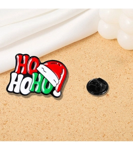 Detail of Christmas enamel pin with HO HO HO text, Santa hat design and rubber back clasp