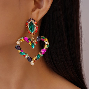 Detailed close-up of a heart-shaped earring featuring colorful crystals and golden base