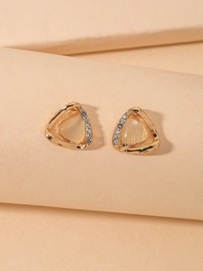 Detailed close-up of golden triangular cat eye stone earrings with zircon border