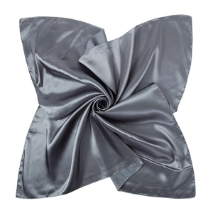 Artistic display of dark grey satin silk square scarf folded into a floral shape