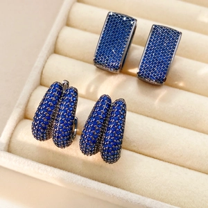 Detail of vintage square and double-row U-shaped earrings with navy blue zircon in a box