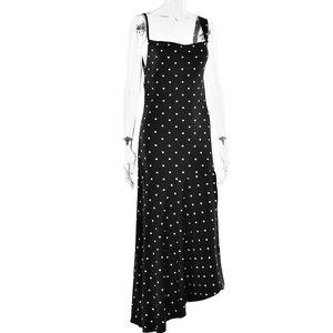 Detailed view of black polka dot slip dress with irregular hem and side split design