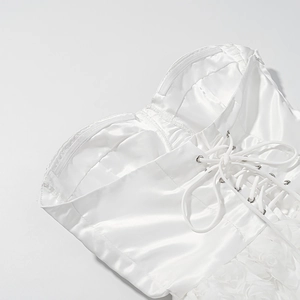 Detail of white satin dress featuring adjustable lace-up back design and built-in bra cups