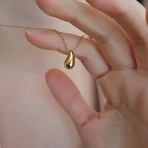 Collier avec pendentif goutte d'eau dorée polie pour femmes au style luxueux minimaliste