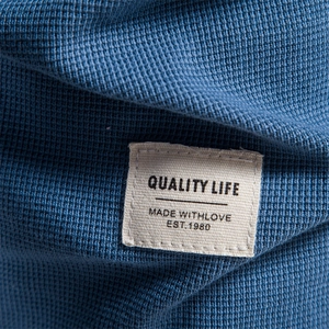 Détail macro de la texture gaufrée bleue et de l'étiquette tissée de haute qualité